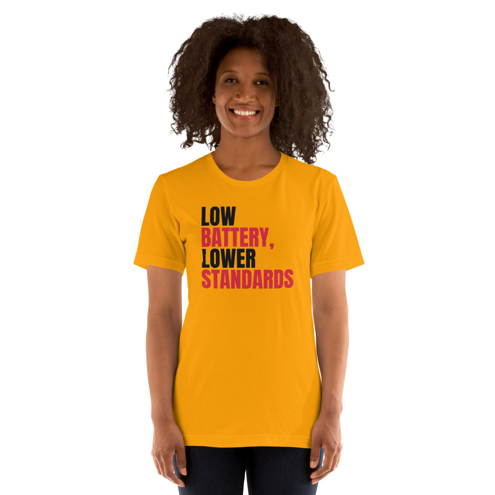 LOW BATTERY, LOWER STANDARDS — printed on a gold t-shirt